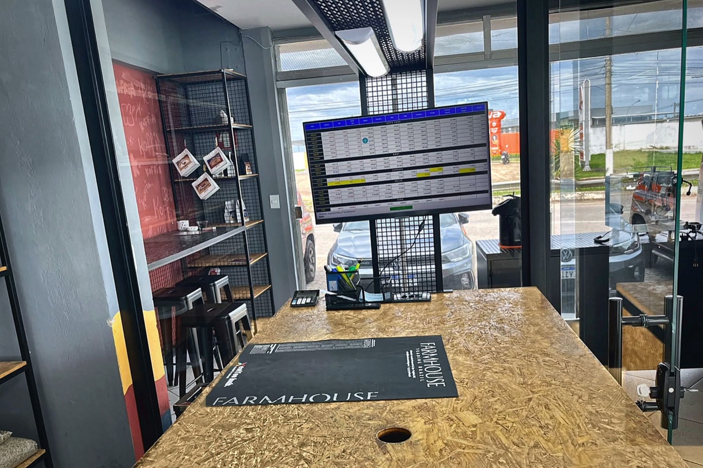 Balcão da Farmhouse no coffee hub, com o painel de cotações do café