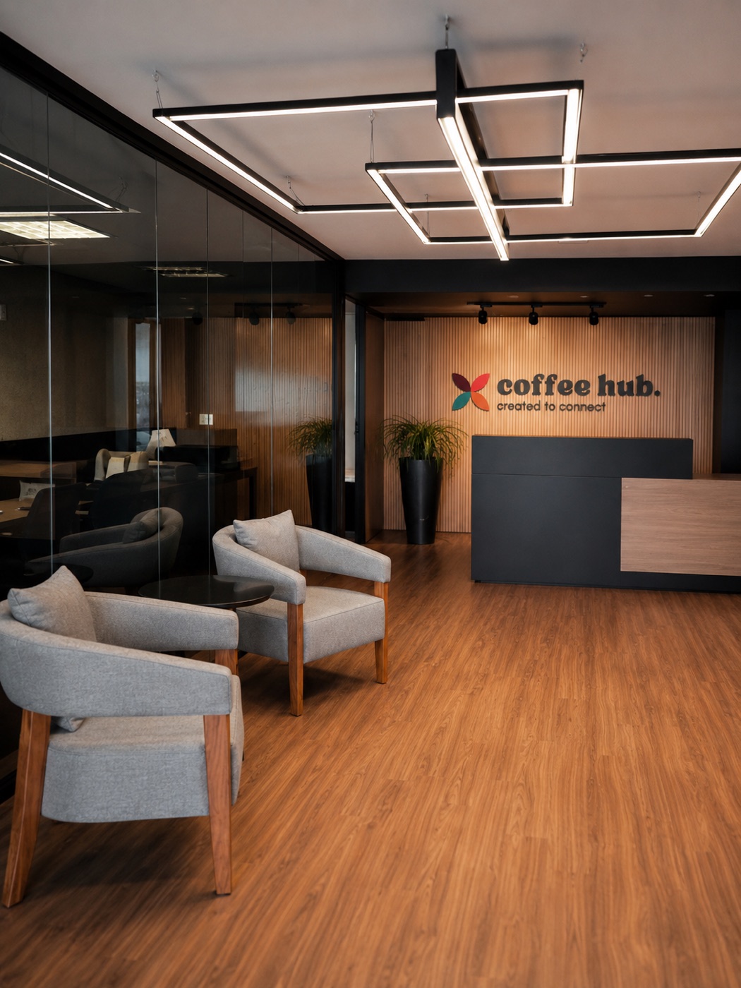 Recepção e lounge do coffee hub, com a marca na parede